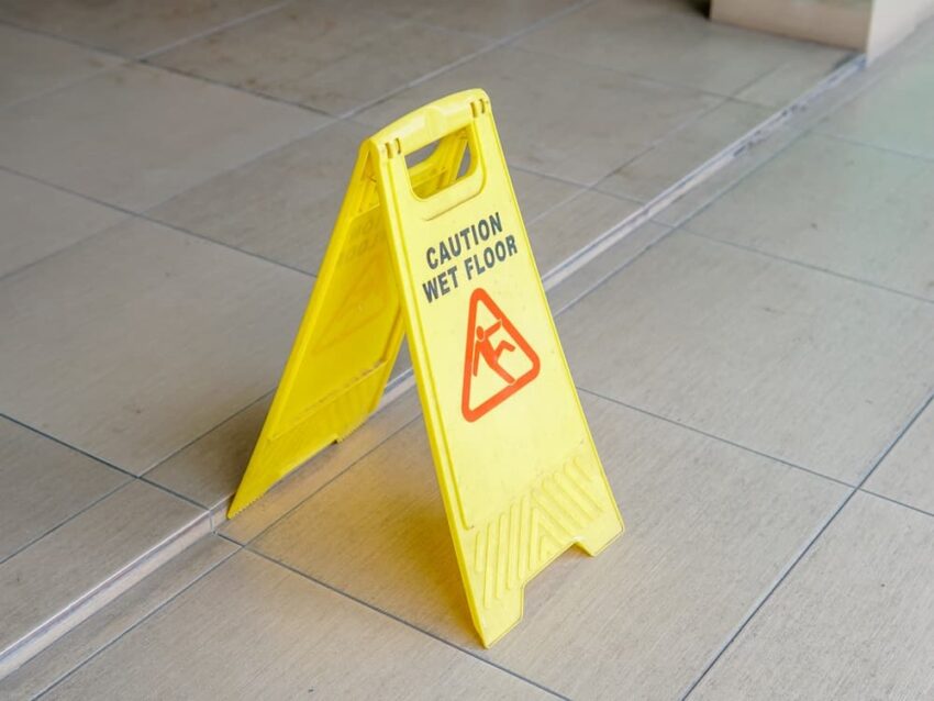Yellow caution wet floor sign stands on the floor in Nursing Home