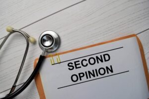 Second Opinion text with document brown envelope and stethoscope isolated on office desk.