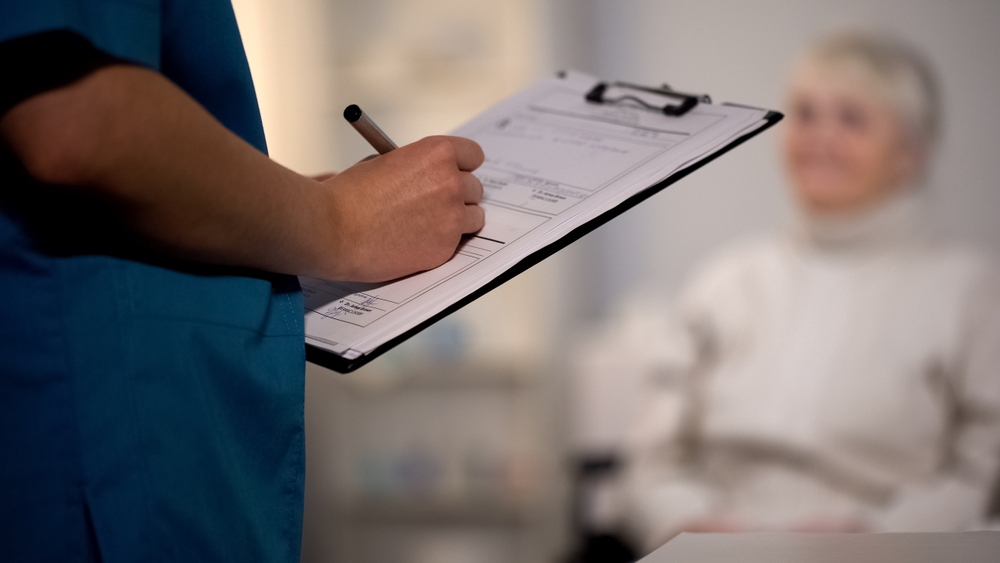 A nurse records patient information on a clipboard during a care assessment at a Charleston nursing home.