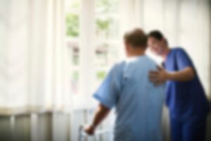 A caregiver assists an elderly resident with walking inside a South Carolina nursing home.