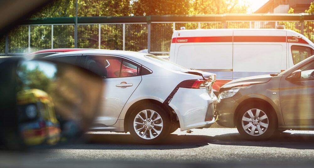 Two cars involved in a rear-end collision with an ambulance parked nearby