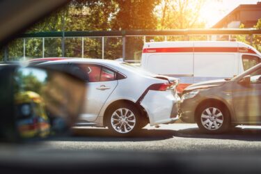 Two cars involved in a rear-end collision with an ambulance parked nearby