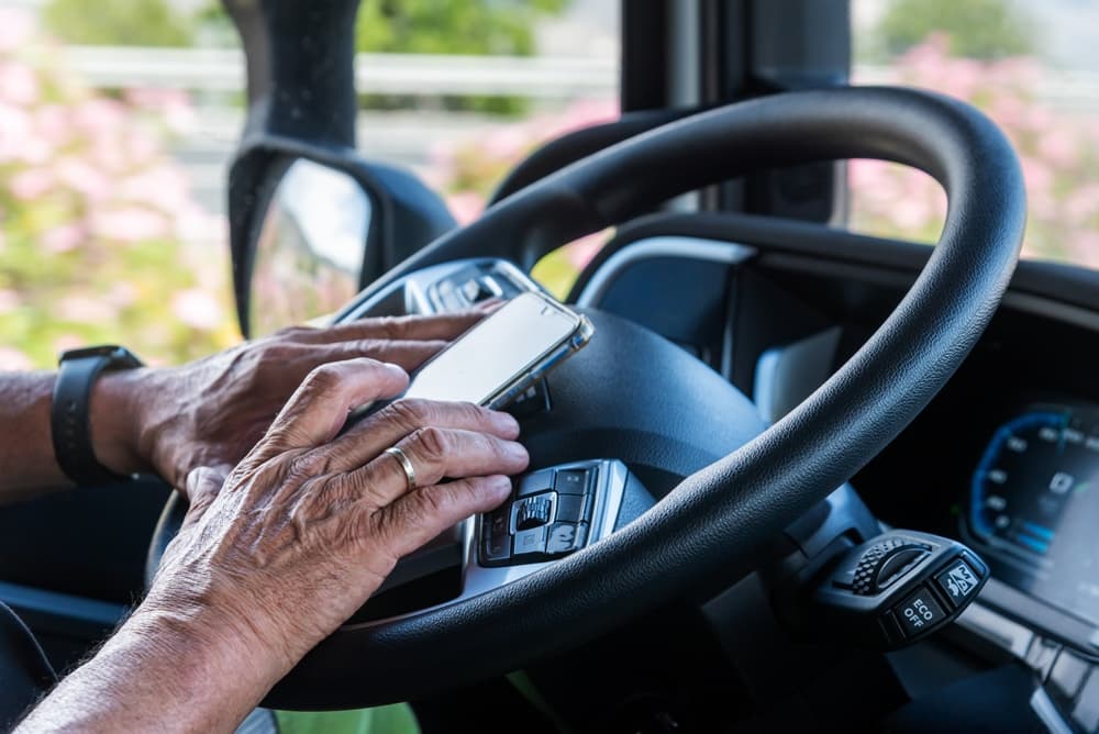 truck driver texting on his mobile phone while driving truck