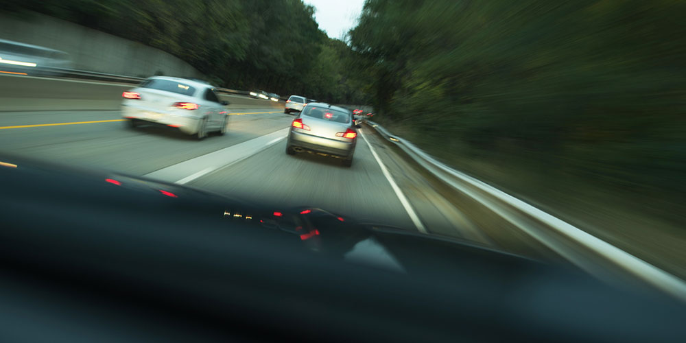 Dashboard view of a two-lane highway with passing traffic, representing the lane-change and blind-spot conditions where sideswipe collisions commonly happen in South Carolina.