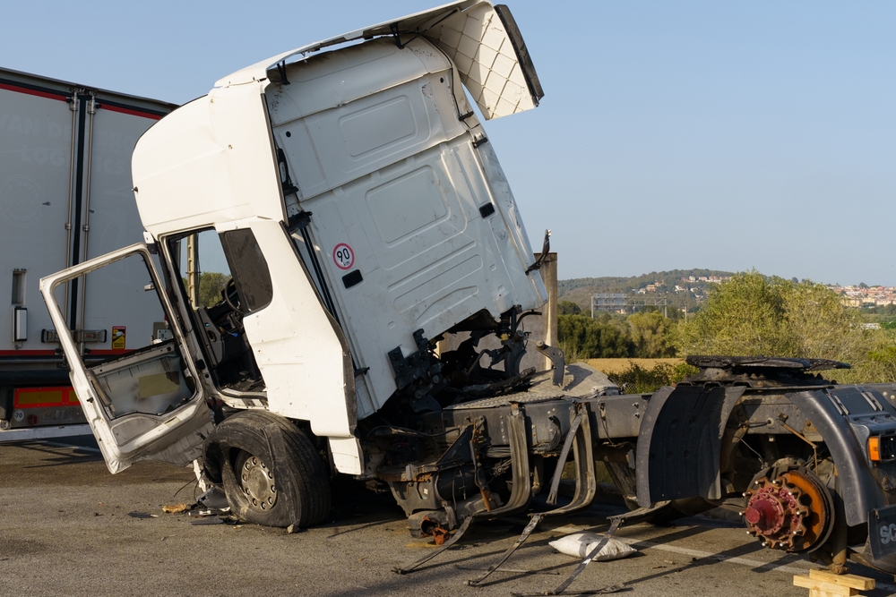 A heavily damaged semi-truck cab after a severe roadway collision.