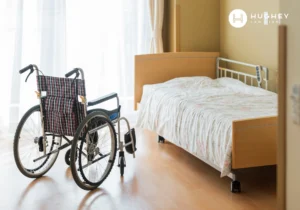 Wheelchair beside a bed in a Charleston nursing home room, highlighting the vulnerability of elderly residents to sexual abuse.